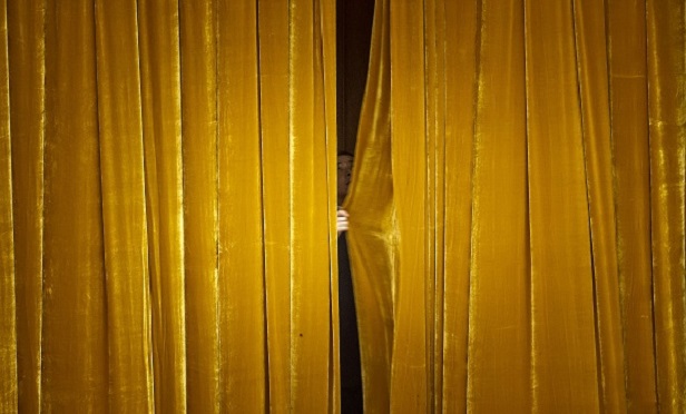 An attendant draws a curtain inside the Great Hall of the People during a group session at the fifth session of the 12th National People's Congress (NPC) in Beijing, China on Wednesday, March 8, 2017. China's NPC will close on March 15. Photographer: Qilai Shen/Bloomberg
