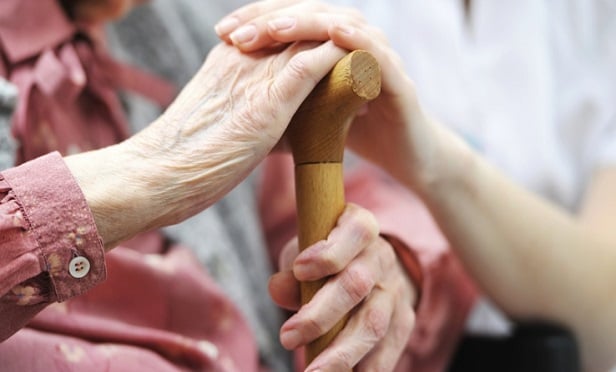 A younger hand clasping an older hand