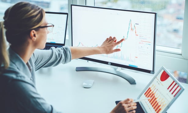 Businesswoman pointing at stock chart on screen