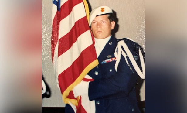 Mark Amberg in uniform holding American flag.