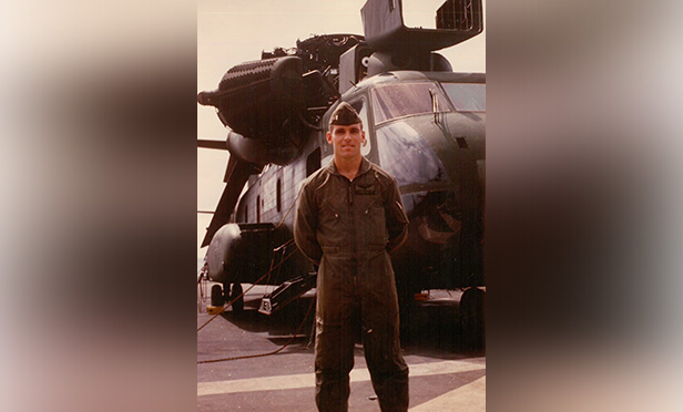 Colin Mackenzie Marine Corps standing next to a helicopter