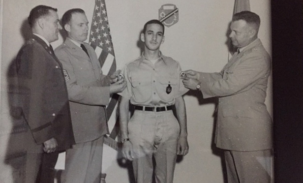 Jeffrey B. Stoll in Army uniform next to a Flag
