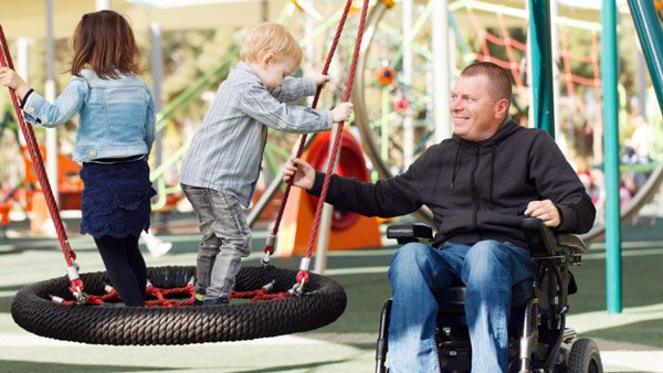 Man in wheelchair with child at playground